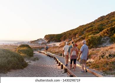 Group Of Senior Friends Walking Along Boardwalk At Beach On Summer Group Vacation - Powered by Shutterstock