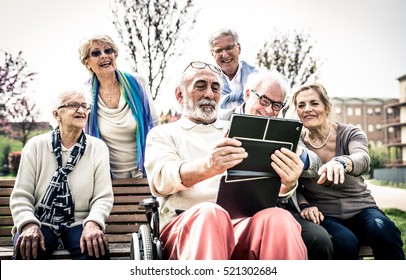 Group of senior looking funny videos on a digital device