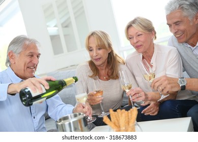 Group of senior people celebrating with champagne