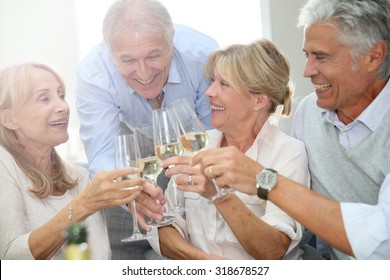 Group Of Senior People Celebrating With Champagne