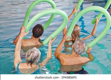 Group of senior people doing aqua fitness from behind with swim noodles - Powered by Shutterstock