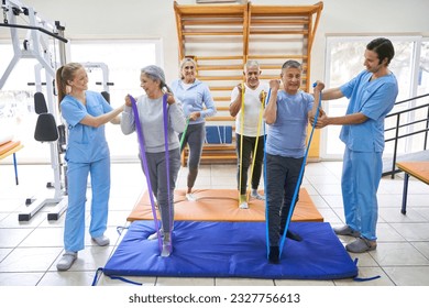 Group of senior people doing workout in fitness class with instructor in gym - Powered by Shutterstock