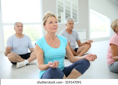 Group Of Senior People Doing Yoga Exercises