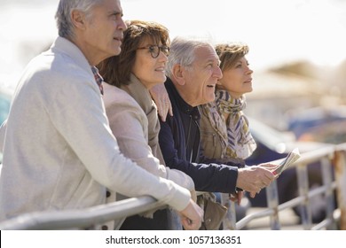 Group Of Senior People On Vacation Leaning On Fence