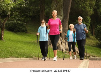 Group of senior people performing Nordic walking outdoors. Low angle view - Powered by Shutterstock