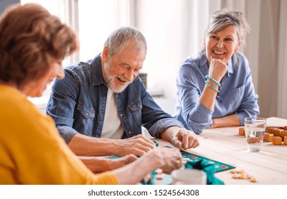 Group of senior people playing board games in community center club. - Powered by Shutterstock