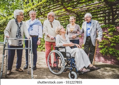 Group of senior people with some diseases walking outdoors - Mature group of friends spending time together