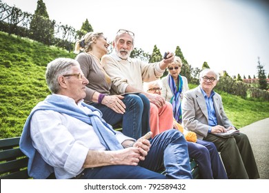 Group of senior people with some diseases walking outdoors - Mature group of friends spending time together