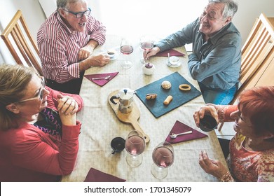 Group Of Senior People Toasting Italian Style Moka Coffee After Lunch - Mature Happy Friends Eating Biscuits And Laughing Together - Focus On Top Left Man Face