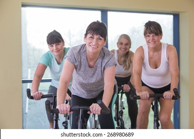 A Group Of Senior Women Using Spinning Bikes At The Gym