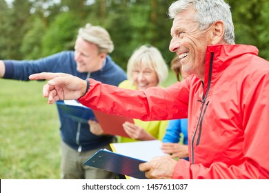 Group Of Seniors Enjoying A Scavenger Hunt Or Geocaching In Nature