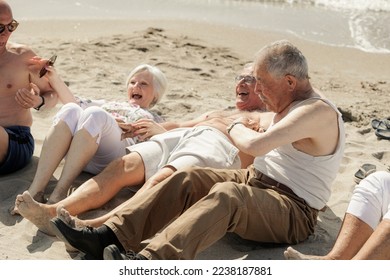 A group of seniors have fun sitting on the beach by the sea - Shutterstock ID 2238187881