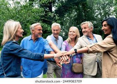 Group of seniors join hands together to cheer and celebrate Old friends spending time together in the main parts of london, visiting the westminster area and st. james park.  - Powered by Shutterstock