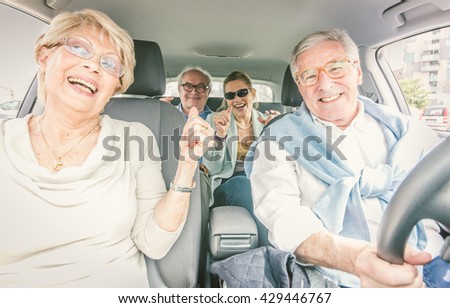 Group of seniors making party in the car while driving