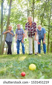 Group Of Seniors Playing Bocce Or Boules Play Together In Nature