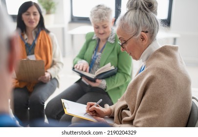 Group Of Seniors With Singing Books Together At Choir Rehearsal.