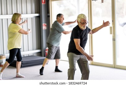 Group Of Seniors In Tai Chi Class Exercising In An Active Retirement Lifestyle. Mental And Physical Health Benefits Of Exercise And Fitness In Elderly People. Senior Health Care And Wellbeing Concept.