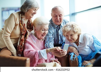 Group Of Seniors Using Mobile Phone