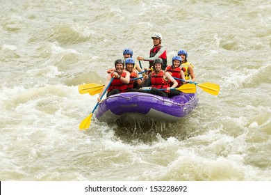 A group of seniors wearing helmets and rowing a raft down a river in South America, enjoying a fun family holiday on the water. - Powered by Shutterstock