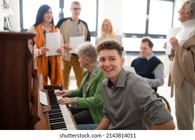 Group of seniors with young teacher singing together at choir rehearsal. - Shutterstock ID 2143814011