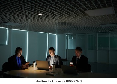 Group Of Serious Business People Working On Secret Project In Dark Modern Office