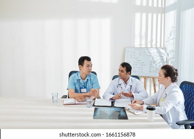 Group Of Serious Medical Workers Discussing Epidemic Situation In The City And Deciding How To Deal With Dangerous Virus