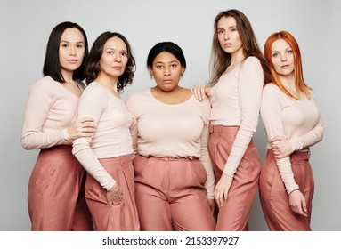 Group Of Serious Women With Different Hair And Color Of Skin Standing Together In Same Outfit