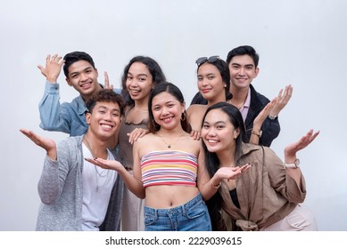 A group of seven close friends in their late teens to early 20s looking at the camera, smiling. Teamwork and unity concept. Isolated on a white backdrop. - Shutterstock ID 2229039615