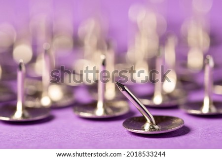 Group of sharp push pins with one crooked and unable to hold something on the foreground. Different, disability, inability