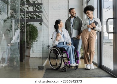 group shot of diverse business people, disabled woman on wheelchair chatting with colleagues