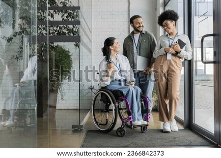 group shot of diverse business people, disabled woman on wheelchair chatting with colleagues