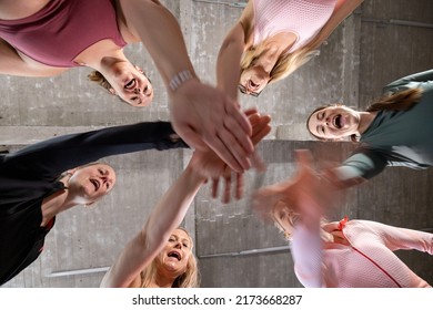 Group Of Six Young Motivated Sporty Girls Wearing Sports Attire Standing Together Forming Hand Stack Before Workout In Fitness Class. High Quality Photo