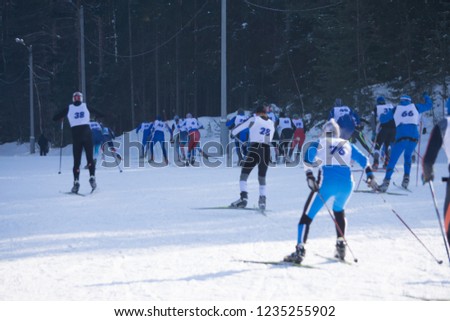 A group of skiers climbs up the snow-covered ski track defocused