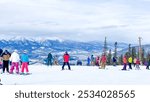 A group of skiers ready to descend the slopes at Keystone, Colorado, with a stunning view of snow-covered mountains in the background.