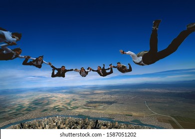 Group Of Skydiving Executives Forming A Circle In Mid-air