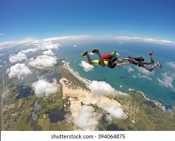 A group of skydiving friends having fun in the skies. Soft focus in background. Ibiraquera Brazil.