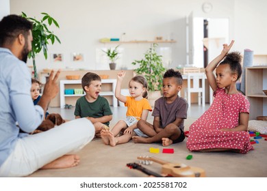 Group of small nursery school children sitting on floor indoors in classroom. - Shutterstock ID 2025581702