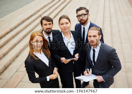 Group of smart business partners looking at camera