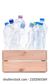 Group of smashed plastic water bottles in wooden crate. Recycle concept studio photo