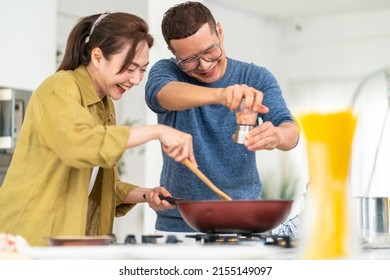 Group Of Smiling Asian People Friends Enjoy Cooking With Talking Together In The Kitchen At Home. Happy Man And Woman Having Dinner Party Meeting Celebration Eating Food Together On Holiday Vacation