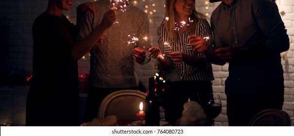 Group of smiling friend having fun with sparkles at home for Christmas in the night. - Powered by Shutterstock