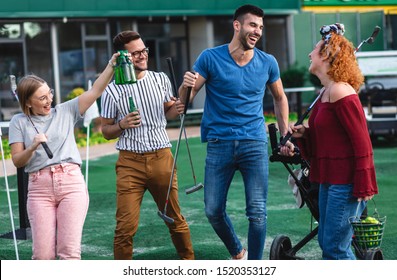 Group Of Smiling Friends Going To Play Mini Golf In The City.