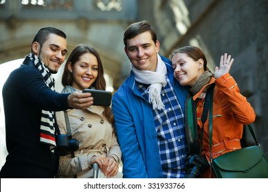 Group Of Smiling Friends Shooting Mutual Portrait On Cell Phone Outdoors