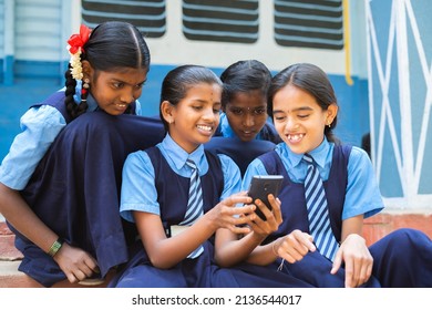 Group Of Smiling Girl Kids Busy Using Mobile Phone At School Corridor During Break - Concpet Of Smartphone Addiction, Using Social Media And Technology