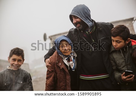 A group of smiling gypsies on the street in a Roma settlement