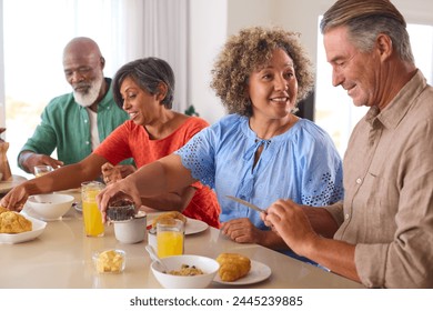 Group Of Smiling Mature Friends On Vacation Or At Home Eating Breakfast Together - Powered by Shutterstock