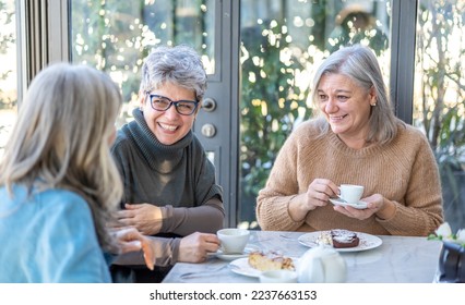 Group of smiling mature women having breakfast together. Three senior female friends laugh together - Powered by Shutterstock