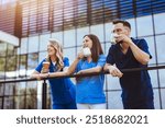 A group of smiling medical professionals in scrubs enjoying a coffee break outside, capturing teamwork, relaxation, and camaraderie in a modern healthcare setting.