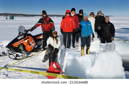 Group Of Smiling People In Sun At An Ice Hole For Cold Water Swimming In Winter  At Kempenfelt Bay Lake Simcoe Barrie, Ontario, Canada - January 23, 2022