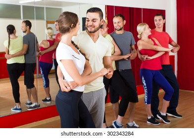 Group Of Smiling Russian People Dancing Salsa In Studio